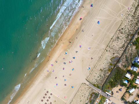 Luchtfoto van Camping Beauregard Plage - Glamping Languedoc-Roussillon met strand en parasols.