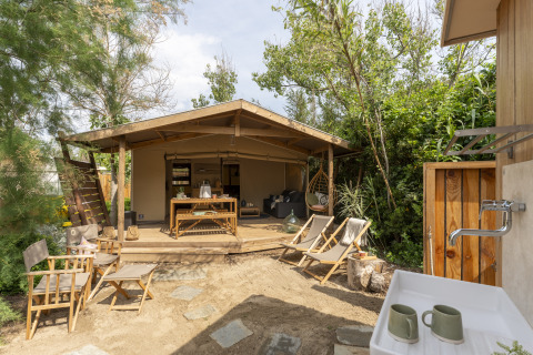 Glamping accommodatie bij Camping Beauregard Plage - Languedoc-Roussillon met houten terras en zitplekken.