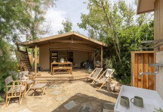 Alojamiento glamping en Camping Beauregard Plage, Languedoc-Roussillon, con terraza y área exterior para sentarse.