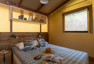 Camera glamping accogliente al Camping Beauregard Plage con arredamento in legno e letto matrimoniale.