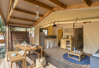Interieur van een glampingaccommodatie bij Camping Beauregard Plage met houten meubels en gezellige sfeer.
