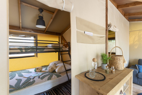 Hébergement glamping au Camping Beauregard Plage en Languedoc-Roussillon avec lits superposés et déco chaleureuse.