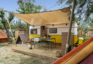Glamping accommodatie op Camping Beauregard Plage - Languedoc-Roussillon, caravan met veranda en schaduw.