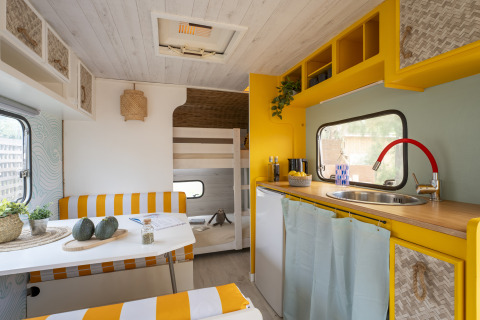 Alloggio glamping moderno al Camping Beauregard Plage in Languedoc-Roussillon, cucina luminosa e zona pranzo.