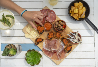 Tapasplatte mit Wurst, Käse, Oliven und Brot auf Camping Beauregard Plage - Glamping Languedoc-Roussillon.