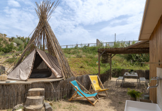 Glamping-ophold ved Camping Beauregard Plage med tipi-telt, liggestole og udendørs spiseområde i Languedoc-Roussillon.