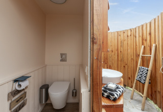 Salle de bain à ciel ouvert avec toilettes et lavabo, Camping Beauregard Plage, Glamping Languedoc-Roussillon