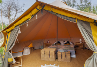 Glamping-tent met sfeervolle inrichting en tweepersoonsbed bij Camping Beauregard Plage, Languedoc-Roussillon.