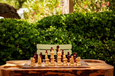 Jeu d'échecs en plein air sur table en bois au Camping Beauregard Plage - Glamping Languedoc-Roussillon.