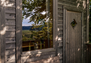 Glampingverblijf Boomhuthotel Uckermark in Brandenburg, houten hut met zicht op de natuur.
