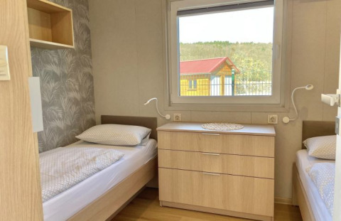 Glamping accommodation at Camping Rhön Feeling - Tiny Houses Thüringen with twin beds and window view.