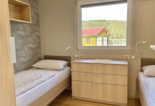 Hébergement glamping au Camping Rhön Feeling - Tiny Houses Thüringen avec deux lits simples et fenêtre.