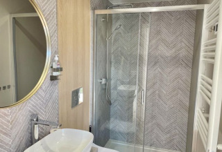 Modernes Badezimmer mit Dusche, Waschbecken und Spiegel in der Glamping-Unterkunft Camping Rhön Feeling.