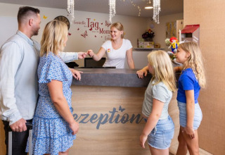 En familie tjekker ind ved receptionen på Camping Rhön Feeling - Tiny Houses Thüringen, glamping sted.