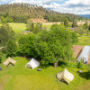 Aerial view of glamping tents at Les Jardins de Biffontaine surrounded by lush fields, trees and a greenhouse.