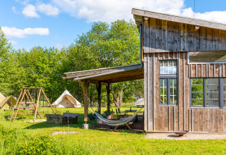 Glamping stay at Les Jardins de Biffontaine with tents, playground, and wooden lodge in scenic nature.