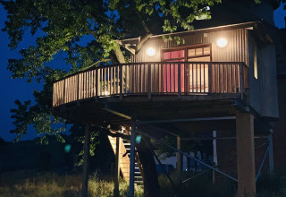 Alloggio glamping o campeggio chiamato 'Boomhut Wesertal - Boomhutten Hessen' nei Paesi Bassi di notte.