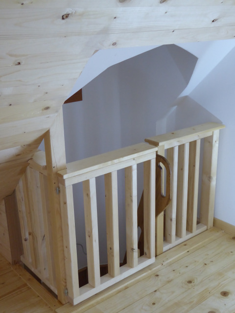 Barandilla y puerta de madera clara en alojamiento glamping Boomhut Wesertal - Boomhutten Hessen.