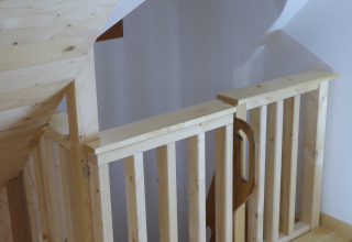 Barrière et rampe d'escalier en bois clair dans un hébergement glamping Boomhut Wesertal - Boomhutten Hessen.