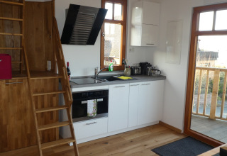 Cucina moderna da glamping in Boomhut Wesertal, Boomhutten Hessen, con dettagli in legno e grandi finestre.