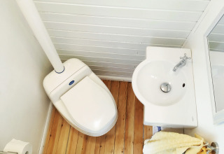 Kompakt badeværelse i glampingindkvartering på Gesundheidshof Denker - Zigeunerwagen Jutland med toilet og håndvask.