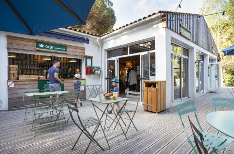 Terrasse du café à Huttopia Chardons Bleus – Ile de Ré, avec familles profitant du site de glamping convivial.