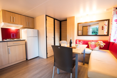 Gemütliche Glamping-Unterkunft auf Camping La Grappe Fleurie in Beaujolais mit Wohnküche und Sitzecke.