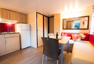 Interno accogliente di sistemazione glamping al Camping La Grappe Fleurie - Glamping Beaujolais con zona pranzo.