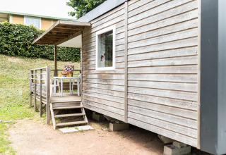 Terrasse extérieure d’un hébergement glamping au Camping La Grappe Fleurie - Glamping Beaujolais avec chaises.