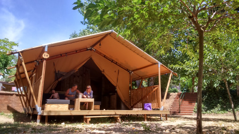 Glamping-Unterkunft bei Camping Lloret Blau mit Safarizelt an der Costa Brava, umgeben von Bäumen.