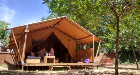 Glamping accommodatie op Camping Lloret Blau met safaritent aan de Costa Brava, omgeven door bomen.