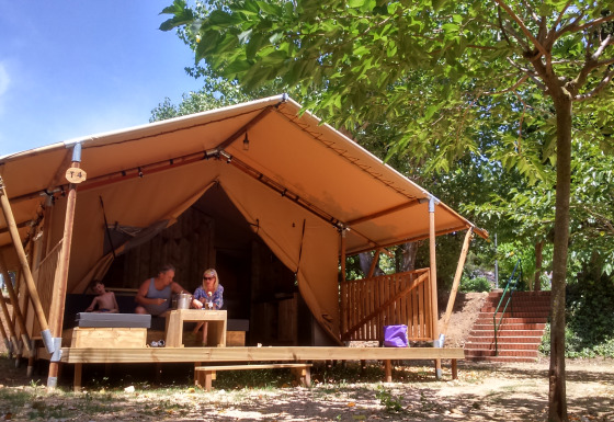 Glampingindkvartering på Camping Lloret Blau med safaritelt i Costa Brava, omgivet af træer og natur.