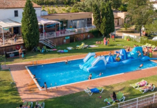 Luftfoto af Camping Lloret Blau - Safaritenten Costa Brava med pool, oppustelig forhindringsbane og gæster.