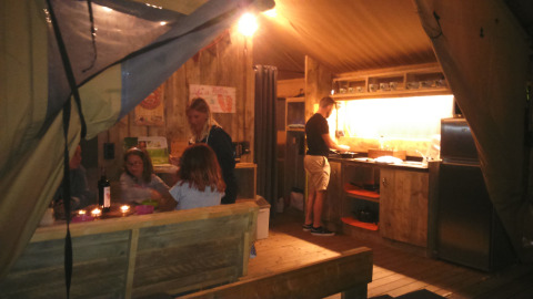 Gezin kookt en eet samen in een safaritent bij Camping Lloret Blau, glamping in Costa Brava.