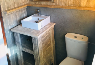Salle de bain dans l'hébergement glamping Camping Lloret Blau Safaritenten Costa Brava avec lavabo et WC.