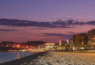 Vista nocturna de la playa y ciudad junto al Camping Lloret Blau - Safaritenten Costa Brava, España.