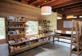 Espace boutique chaleureux chez Camping Huttopia De Veluwe avec murs en bois et produits de glamping en rayon.