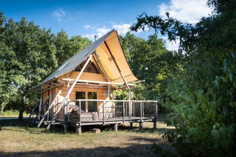 Glamping accommodatie bij Village Huttopia Sud Ardèche, moderne houten lodge met veranda midden in de natuur.