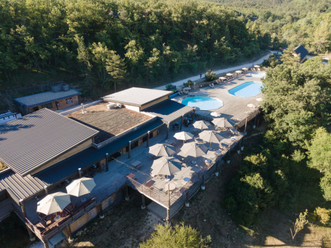 Luftfoto af Village Huttopia Sud Ardèche glamping med pool og skovklædt område i Ardèche, Frankrig.