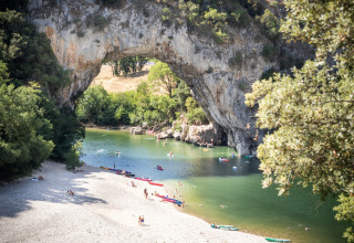 Playa fluvial y arco natural en Ardèche, cerca de Village Huttopia Sud Ardèche – Glamping Ardèche, Francia.