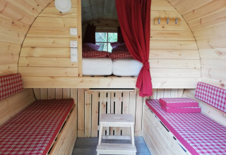 Innenraum einer besonderen Glamping-Unterkunft aus Holz mit roten Karos in Camping Hetzingen, Nordrhein-Westfalen.