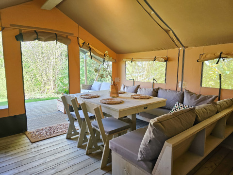 Cozy glamping tent interior at Minicamping Sint Jan - Safaritenten Zeeland featuring wooden furniture.