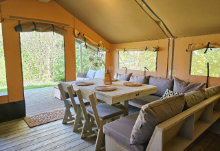 Cozy glamping tent interior at Minicamping Sint Jan - Safaritenten Zeeland featuring wooden furniture.