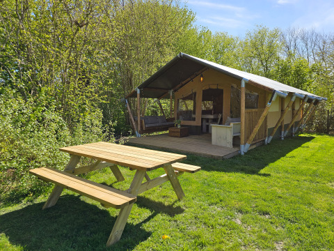 Glamping safaritent op Minicamping Sint Jan in Zeeland, Nederland, met picknicktafel op het gras.