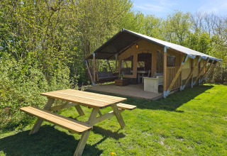 Glamping safaritent op Minicamping Sint Jan in Zeeland, Nederland, met picknicktafel op het gras.