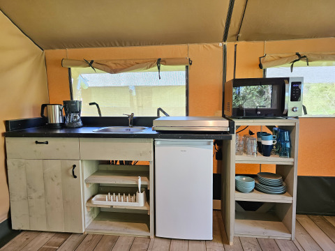 Cucina completamente attrezzata in una tenda glamping a Minicamping Sint Jan - Safaritenten Zeeland, Paesi Bassi.