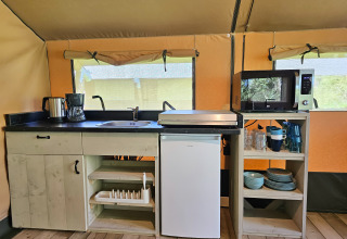 Cucina completamente attrezzata in una tenda glamping a Minicamping Sint Jan - Safaritenten Zeeland, Paesi Bassi.
