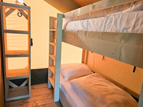 Moderne glampingaccommodatie met stapelbedden en houten meubels bij Minicamping Sint Jan - Safaritenten Zeeland.