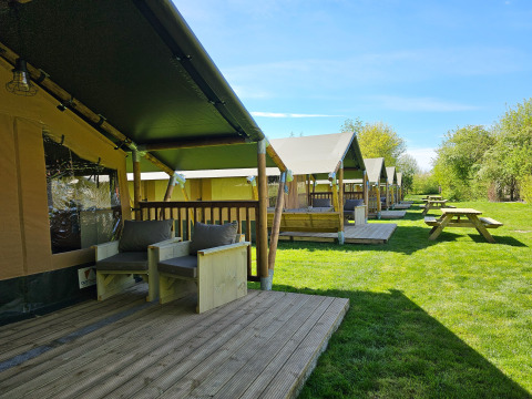 Moderne glamping tenten bij Minicamping Sint Jan - Safaritenten Zeeland op een zonnige groene grasveld.