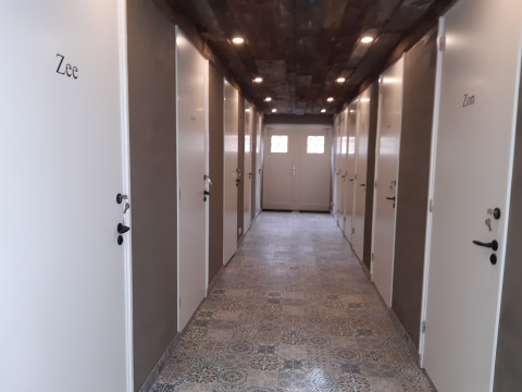 Gang in Minicamping Sint Jan met witte deuren naar safaritenten, genoemd Zee en Zon, Zeeland, Nederland.